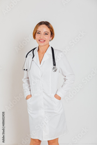 Woman doctor in white coat with phonendoscope stethoscope on white background