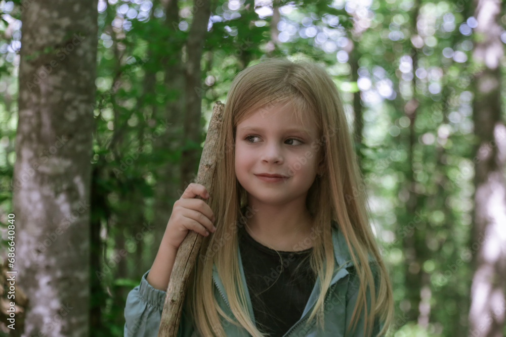 Adorable little girl hiking in the forest, spending time in the nature, outdoors experience in the countryside Adorable little girl hiking in the forest, spending time in the nature, outdoors experience in the countryside