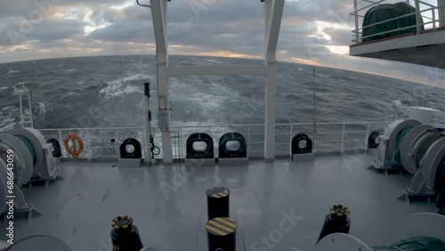 Storm. Sea. Stern of ship in storm. Splashes of water fly up. Strong pitching.