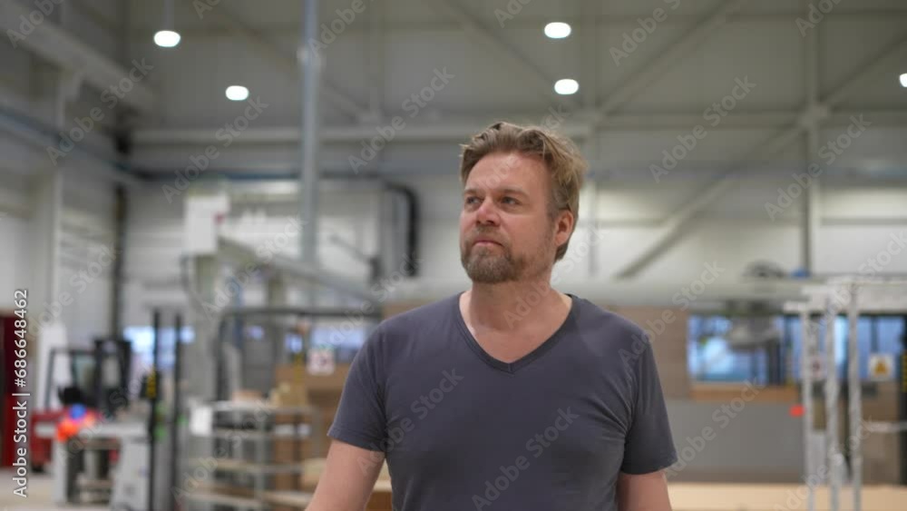 Worker walks happily through factory hall Worker walks happily through factory hall