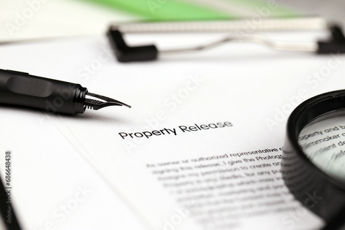 Property Release on A4 tablet lies on office table with pen and magnifying glass close up photo