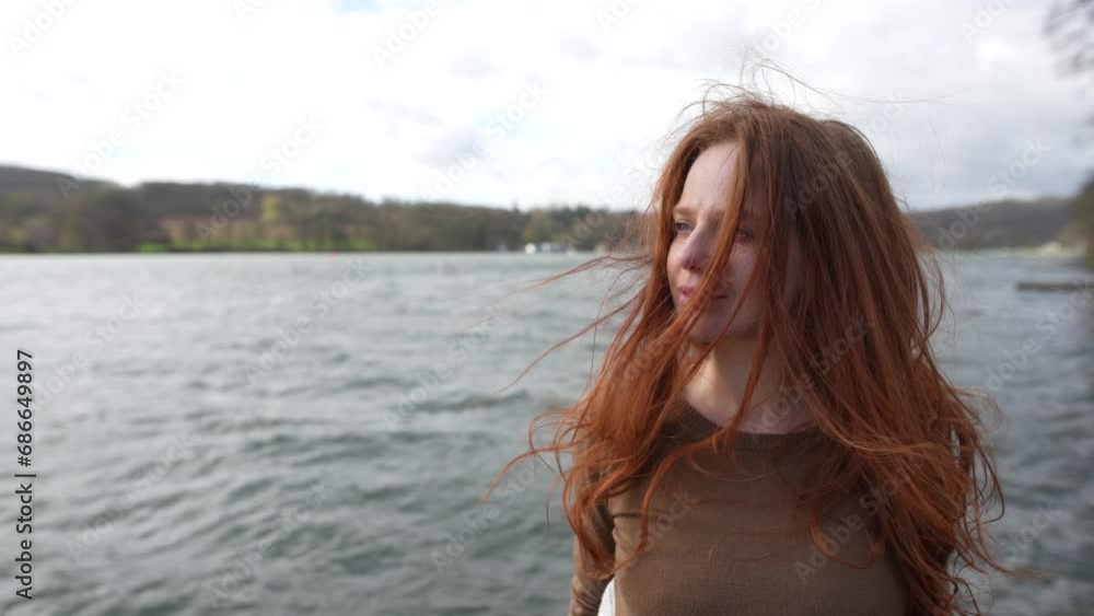 red-haired woman takes a deep breath on the lakeshore red-haired woman takes a deep breath on the lakeshore