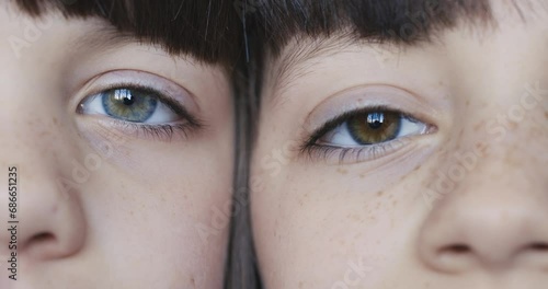 Eyes of two girls looking into the camera opening and closing eyes photo