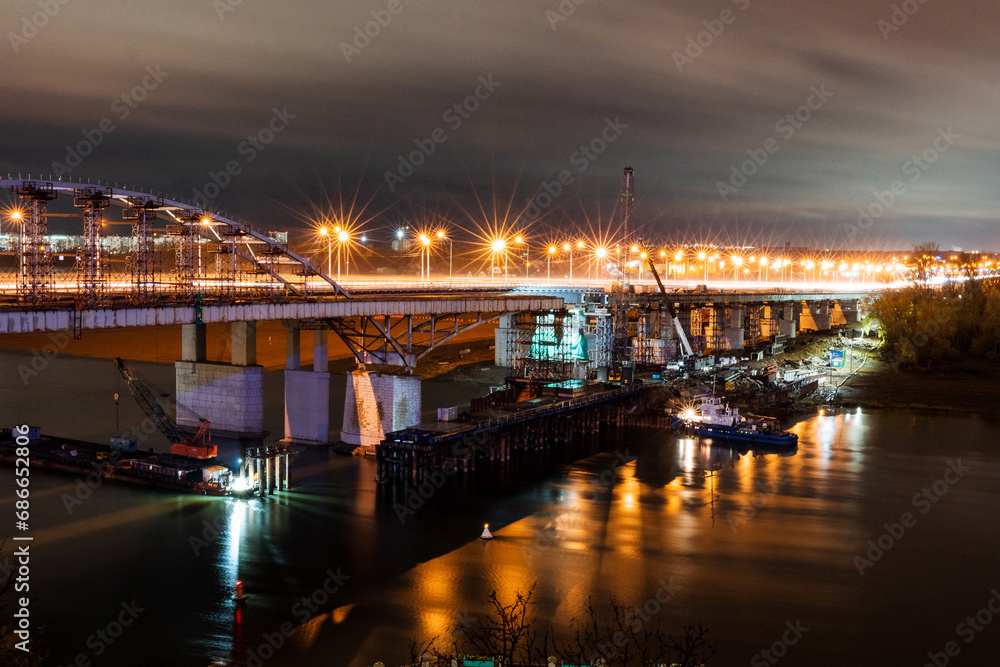 Bridge over river at night in the light of lanterns, night landscape, road bridge.