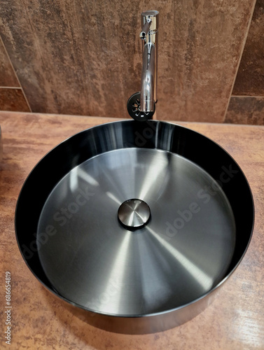 titanium color basin polished in a circle shape. luxury bathroom with brown tiles. counter, asian, wok, gray