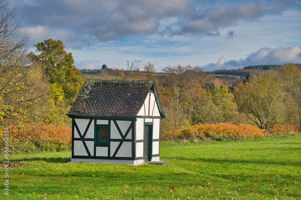small half-timbered house in a colorful autumnal landscape in October small half-timbered house in a colorful autumnal landscape in October