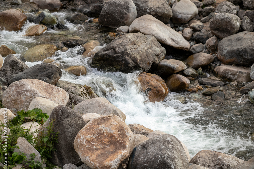 Water flows among the stones. Flow of water and stones. Stones in flowing water. Water conservation concept