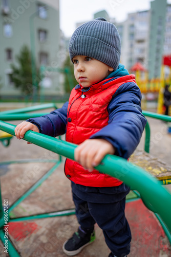 A little boy in a red jacket and a gray hat. A Little Boy in a Red Jacket and a Gray Hat © Vadim