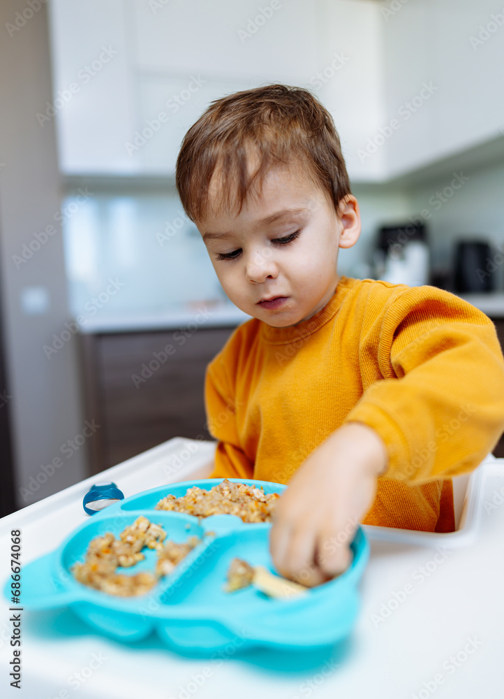 A little boy that is sitting at a table. A Curious Little Boy Sitting at a Table, Discovering the World Around Him A little boy that is sitting at a table. A Curious Little Boy Sitting at a Table, Discovering the World Around Him