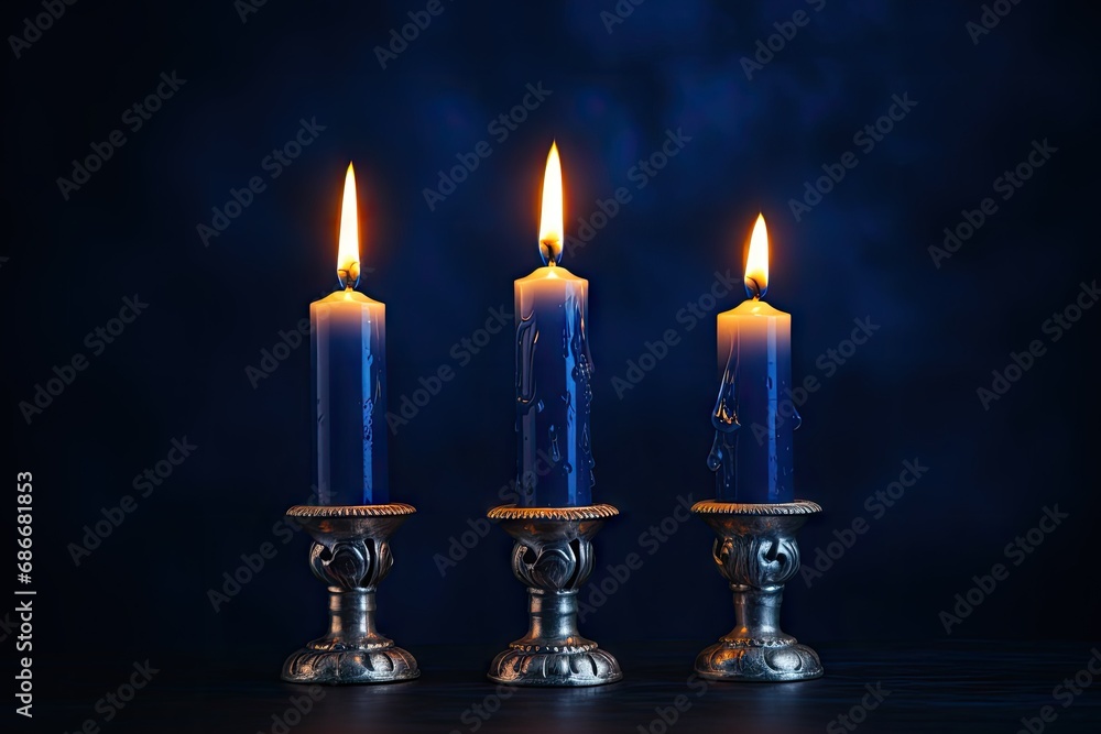 Candlesticks with burning candles on dark blue background Candlesticks with burning candles on dark blue background