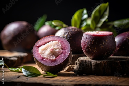 A detailed view of a sliced open Mangosteen showcasing its white flesh, with its vibrant rind and leaf on a wooden surface photo