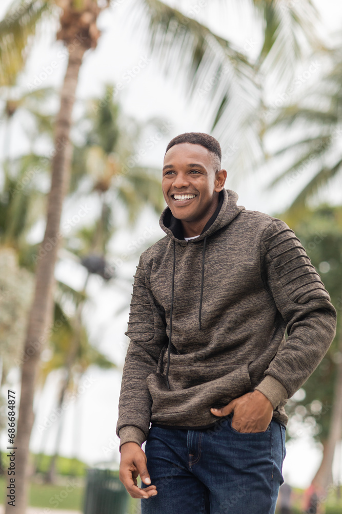 happy african american man in hoodie standing with hand in pocket of jeans happy african american man in hoodie standing with hand in pocket of jeans