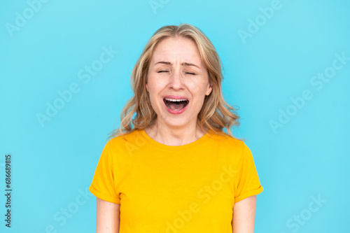 Portrait of crying emotional desperated woman screaming loudly in studio