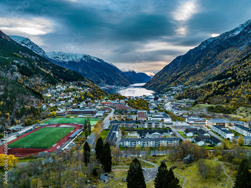 Obraz na płótnie aerial view over town of odda on fjord with mountains covered with snow on background in norway w salonie