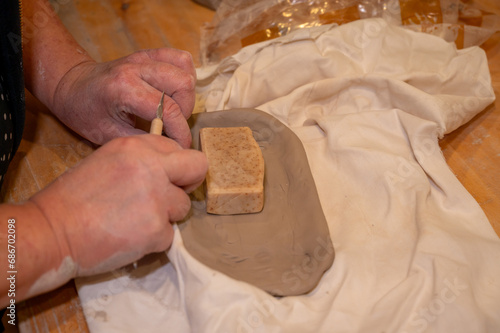 Hands making things with rolled clay in studio photo