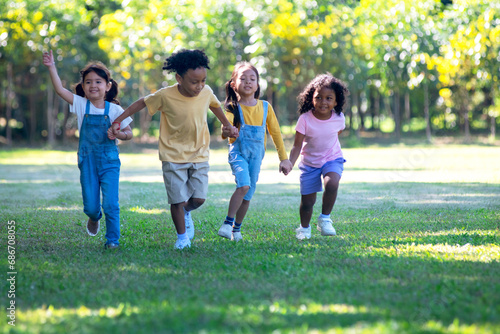 Group of children running in the park, children of different nationalities running and playing on a bright summer day in the park