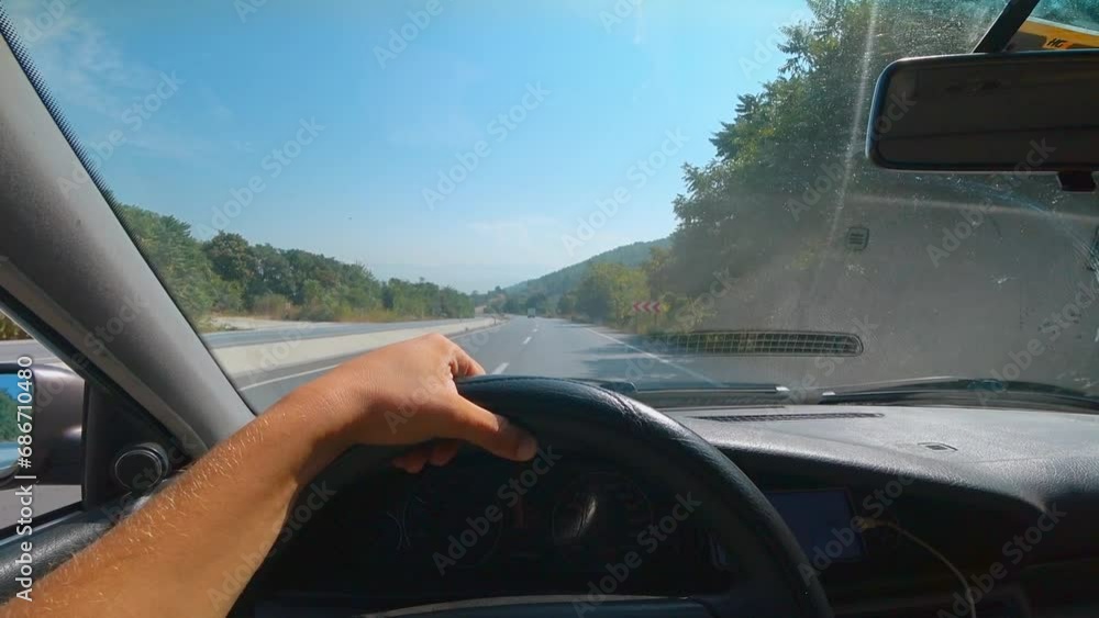 First person view of car on asphalt road through windshield of car. Driver's hands holding steering wheel. Along road nature, mountains and beautiful landscapes of Turkey. First person view of car on asphalt road through windshield of car. Driver's hands holding steering wheel. Along road nature, mountains and beautiful landscapes of Turkey.