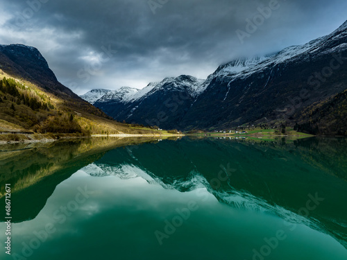 scenic norwegian landscape with mountains, cabin on shore of the cyan Oldevatn lake with reflections