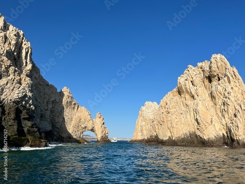 boats floating on the water near some rocks in the ocean: Baja California