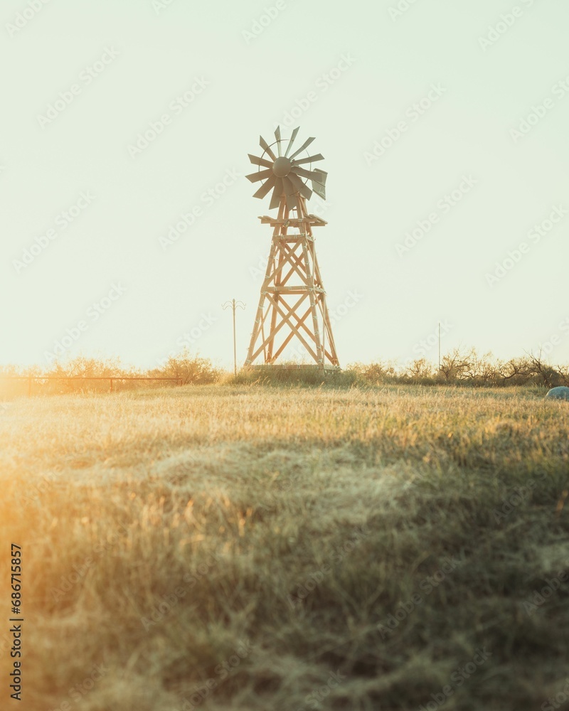 Vertical of an old windmill in a field at sunset in Texas