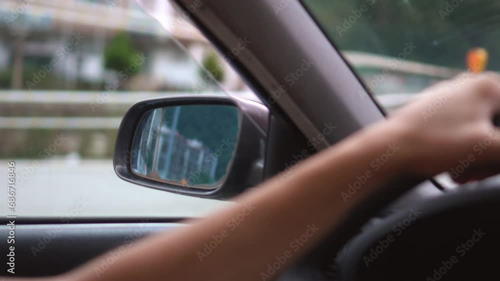 Man driving car side view inside cabin . Close-up of driver's hands lying on steering wheel of car, overlooking passing surroundings and landscapes. Man driving car side view inside cabin . Close-up of driver's hands lying on steering wheel of car, overlooking passing surroundings and landscapes.