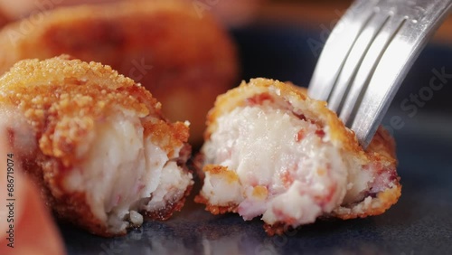 Spanish tapas, Fried portuguese croquettes close-up macro. Breaded croquette of fish, potatoes and ham. Man cooking spanish food.  photo