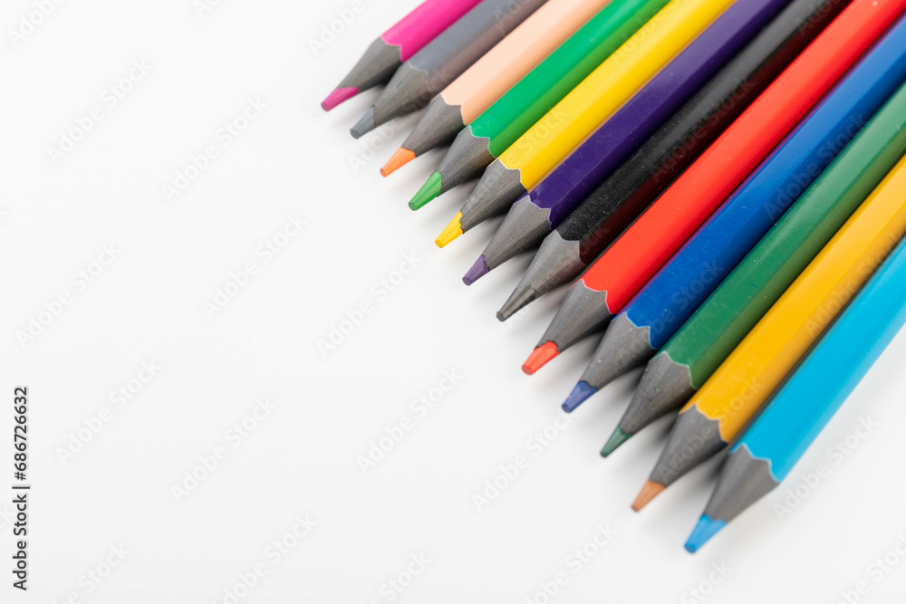 Wooden color pencils arranged in row on white isolated background. Selective focus