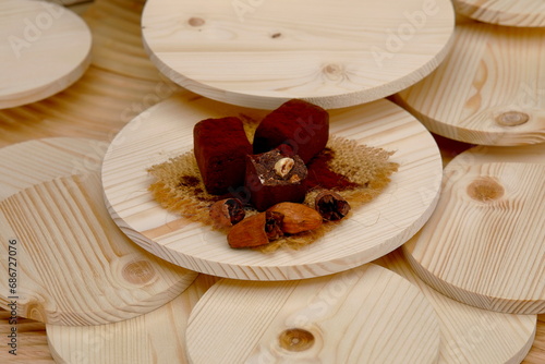 Tartufi di cioccolato extrafondenti con nocciole e fave di cacao su sfondo di legno photo