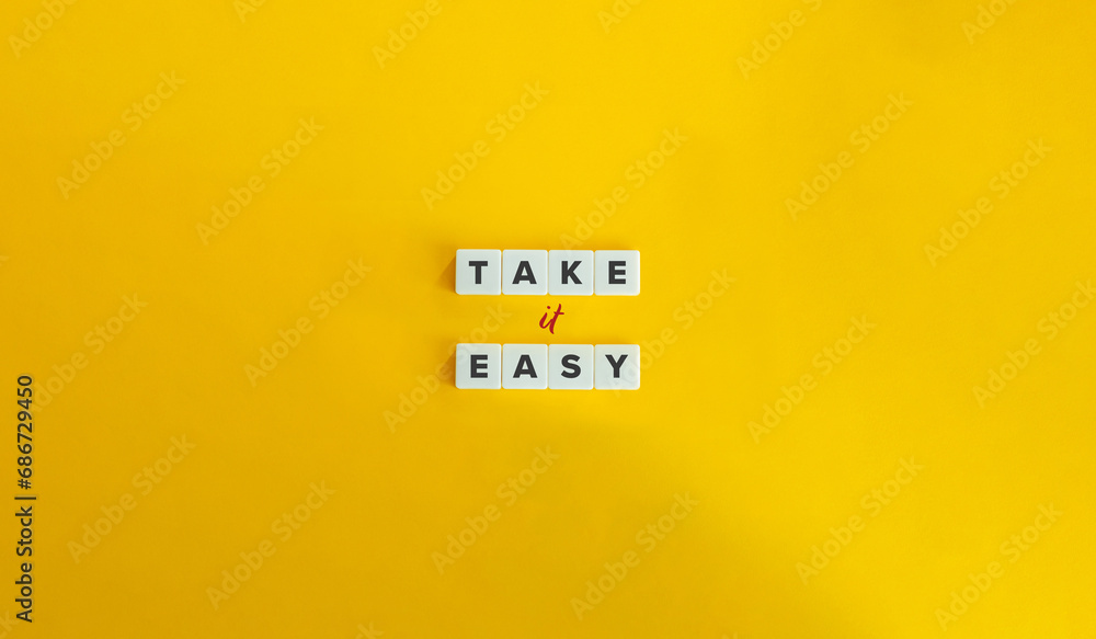 Take It Easy Phrase. Block Letter Tiles on Yellow Background. Minimalist Aesthetics.