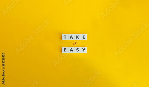 Take It Easy Phrase. Block Letter Tiles on Yellow Background. Minimalist Aesthetics.