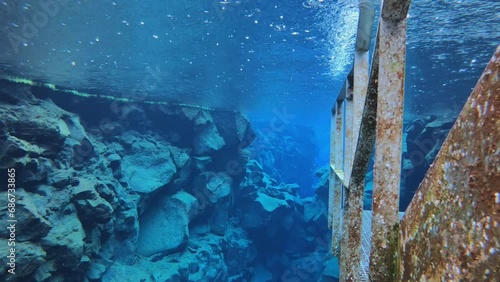 SLOW MOTION SHOT - Silfra is a fissure between the North American and Eurasian tectonic plates with over 100m visibility underwater in Thingvellir National Park, Iceland. photo