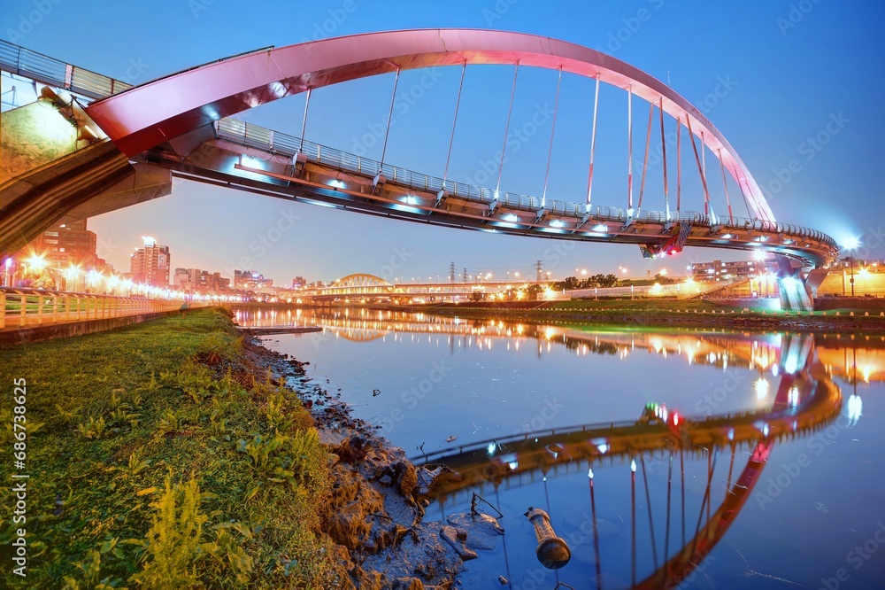 The famous Rainbow Bridge over Keelung River with reflections in the water at blue dusk, in Taipei, Taiwan, Asia ~A romantic landmark of Taipei, the capital city of Taiwan, under beautiful evening sky - obrazy, fototapety, plakaty 