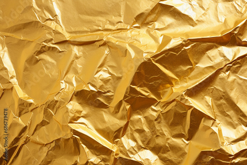 Crumpled gold foil paper abstract background. Textured backdrop.