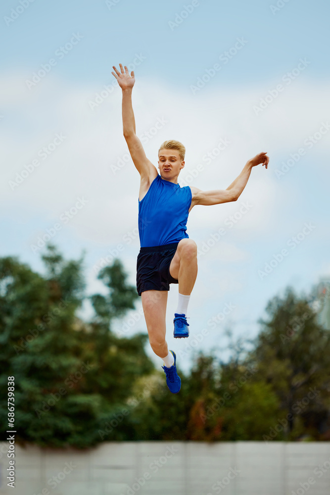 leap of determination frozen in this captivating long jump photo. motivated young man, professional sportsman doing perfect jump. leap of determination frozen in this captivating long jump photo. motivated young man, professional sportsman doing perfect jump.