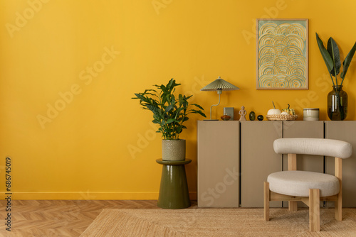 Interior design of yellow living room interior with mock up poster frame, copy space, stylish lamp, vase with leaves, plants, bowl, candle and personal accessories. Home decor. Template. photo