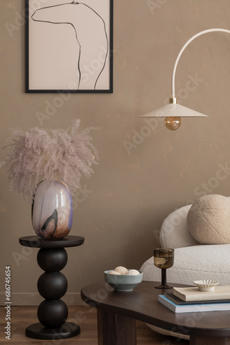 Aesthetic composition of cozy living room interior with mock up poster frame, gray armchair, wooden sideboard, round stand, lamp, stylish rug and personal accessories. Home decor. Template.