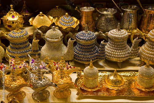 Decorative teapots and traditional Turkish oil lamps for sale in brass, copper and bedazzeled with gems on display in a shop in the Spice Bazaar in the Fatih District; Istanbul, Turkey photo