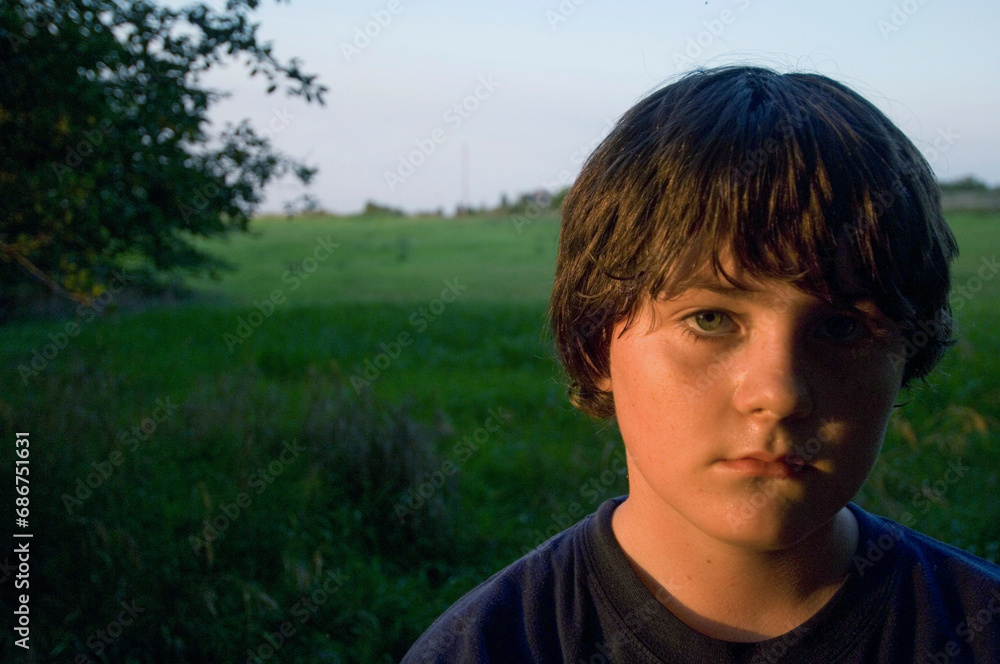 Outdoor portrait of a boy in sunset light; Walton, Nebraska, United States of America. Outdoor portrait of a boy in sunset light; Walton, Nebraska, United States of America.