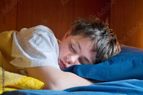 Teenage boy asleep in his bed; Halsey, Nebraska, United States of America photo