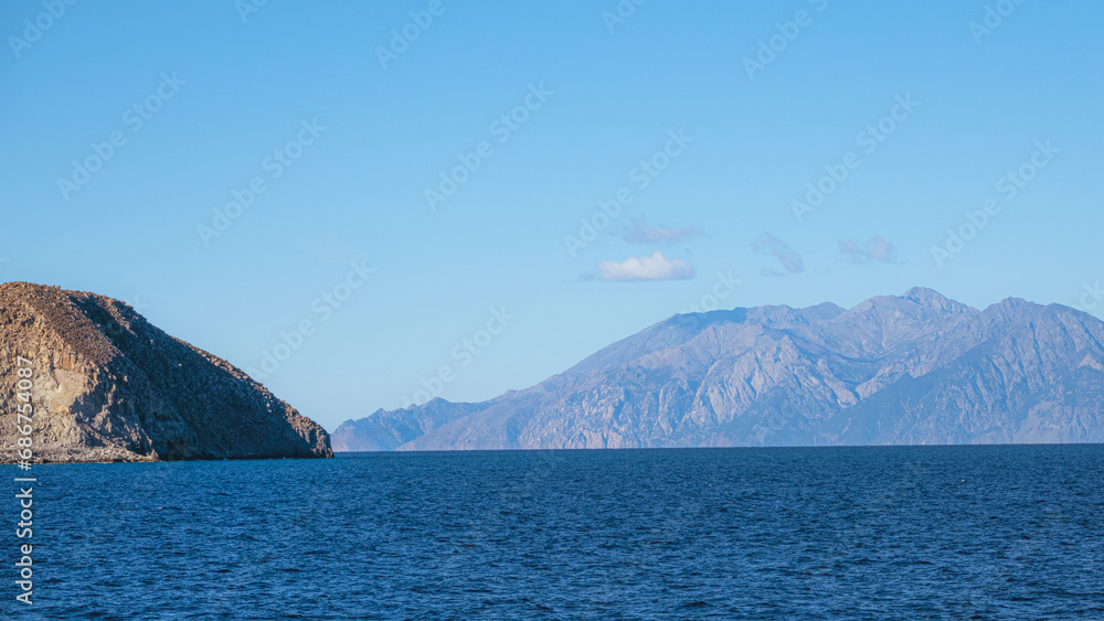 View of the Greek island Samothrace from the ship deck in Gokçeada Island, Turkey.The small rocky mountain on the left belongs to Gokceada. In this frame, two islands appear side by side. View of the Greek island Samothrace from the ship deck in Gokçeada Island, Turkey.The small rocky mountain on the left belongs to Gokceada. In this frame, two islands appear side by side.