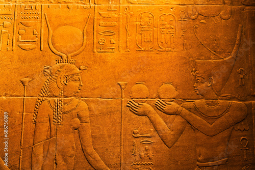 Close-up of bas-relief of hieroglyphs and the Goddess Isis inside the Temple of Isis at Philae Island in the Nile River with golden light; Aswan, Egypt photo