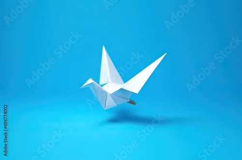 day of peace, a white paper dove made with origami on a blue background