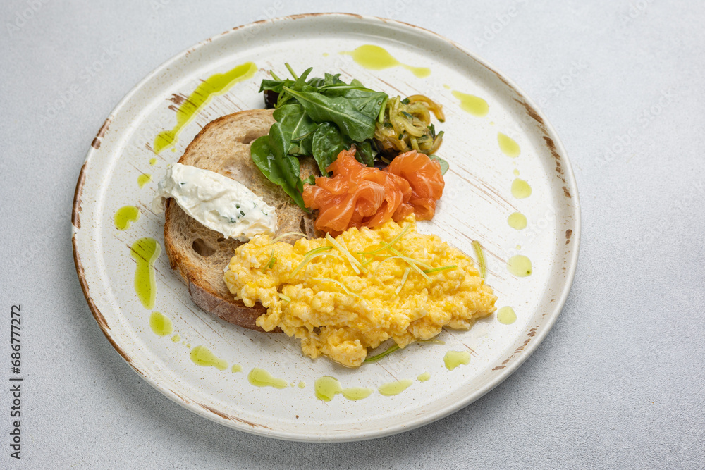 Delicious breakfast - Scrambled eggs with cheese, toast and salmon Delicious breakfast - Scrambled eggs with cheese, toast and salmon