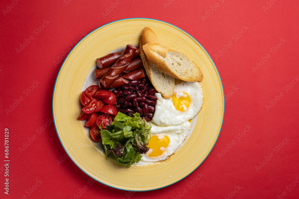 Delicious breakfast - Eggs with sausages, beans, and tomatoes