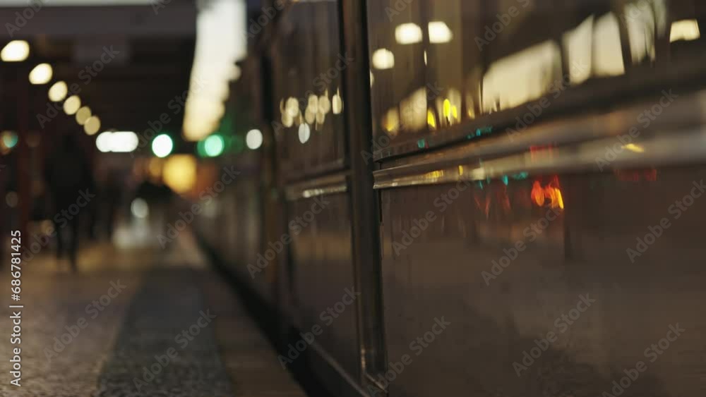 A train that is mooving next to a platform and people A train that is mooving next to a platform and people