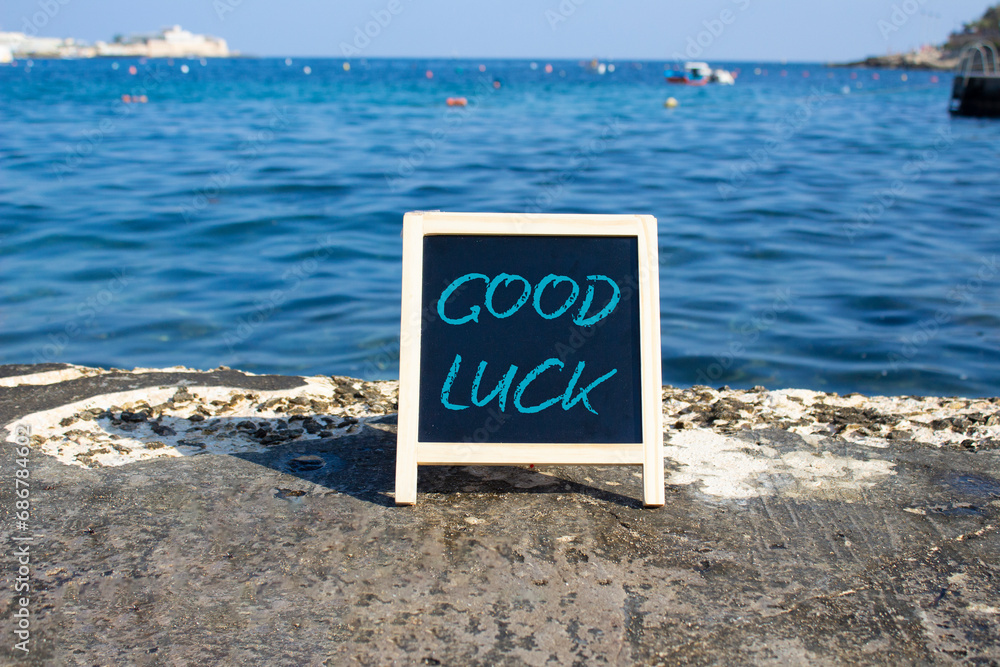 Good luck symbol. Good luck black chalk blackboard. Beautiful sea background. Business and Good luck concept. Copy space.