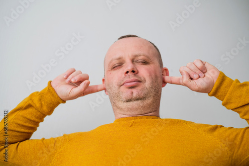 Portrait of young man's hand in yellow sweater saying stop or not accepting a new project photo