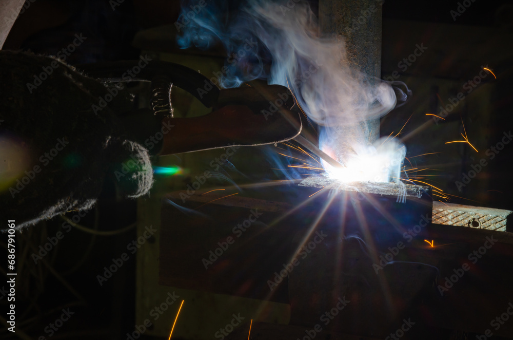 A man welds two pieces of metal together A man welds two pieces of metal together