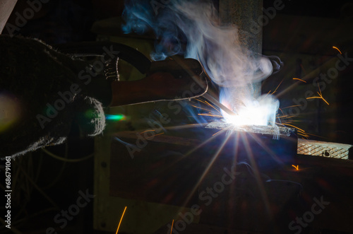 A man welds two pieces of metal together