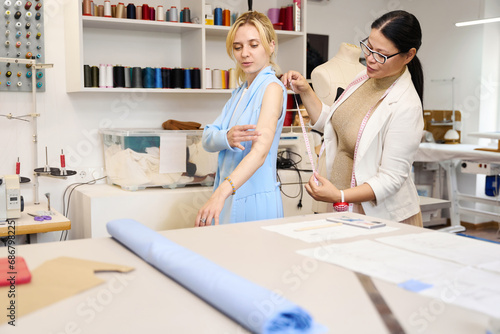Customer is being fitted by experienced craftswoman in sewing studio
